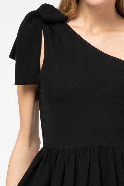 Close up of tied one shoulder strap on little black dress.