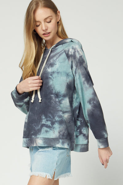 Side view of Women's lightweight hooded pullover in blue tie dye paired with shorts.