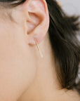 Close up of model's ear wearing Minimalist Gold Earrings for Women mini thread.