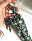 Scarf key chain in hunter green floral print hooked to keys.