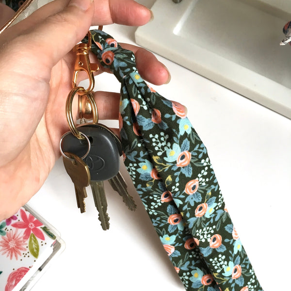 Scarf key chain in hunter green floral print hooked to keys.