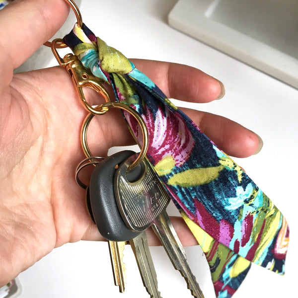 Scarf key chain in lilac floral print hooked to keys.