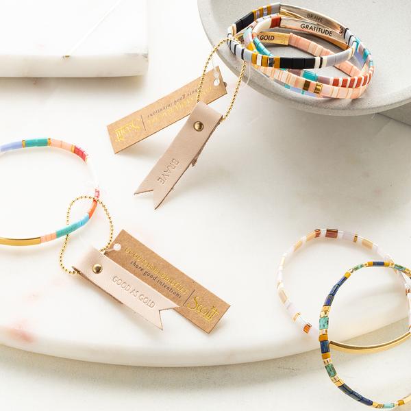 Colorful glass bracelet shown on display with others in different colors.