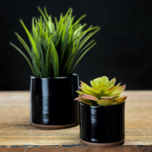 Small pottery planters in black glaze.
