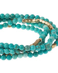 Women's turquoise bohemian jewelry. Close up view of turquoise and gold stone wrap.