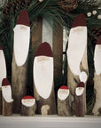 Wooden Santa logs displayed in a group.