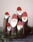 A smaller group gathering of wooden Santa logs.